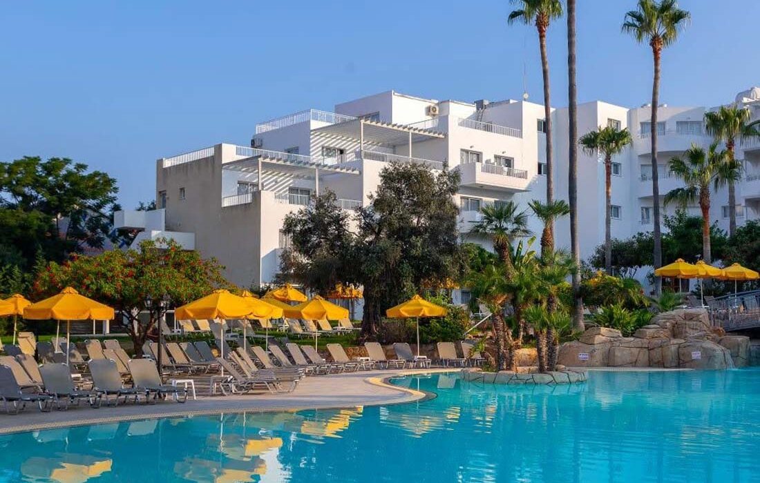 Outdoor pool with yellow umbrellas at Mayfair Hotel & Gardens for holidays in Paphos